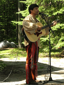 Portrait of Genot Picor in traditional voyageur attire performing with his fiddle